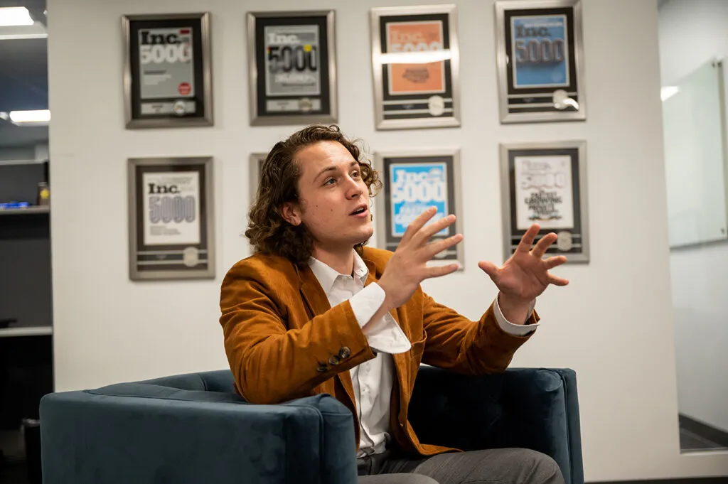 Man In Tan Blazer Talking While Sitting In Armchair
