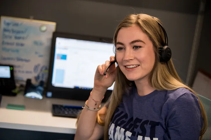 Woman In Blue Shirt Talking On Headset