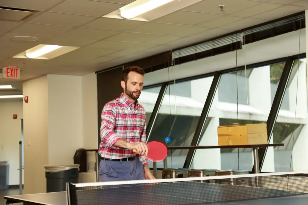 An Employee Having Downtime Playing Ping Pong Table Tennis