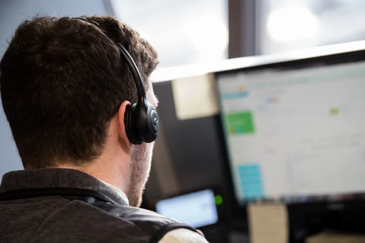 Man With Headset Infront Of Computer Screen