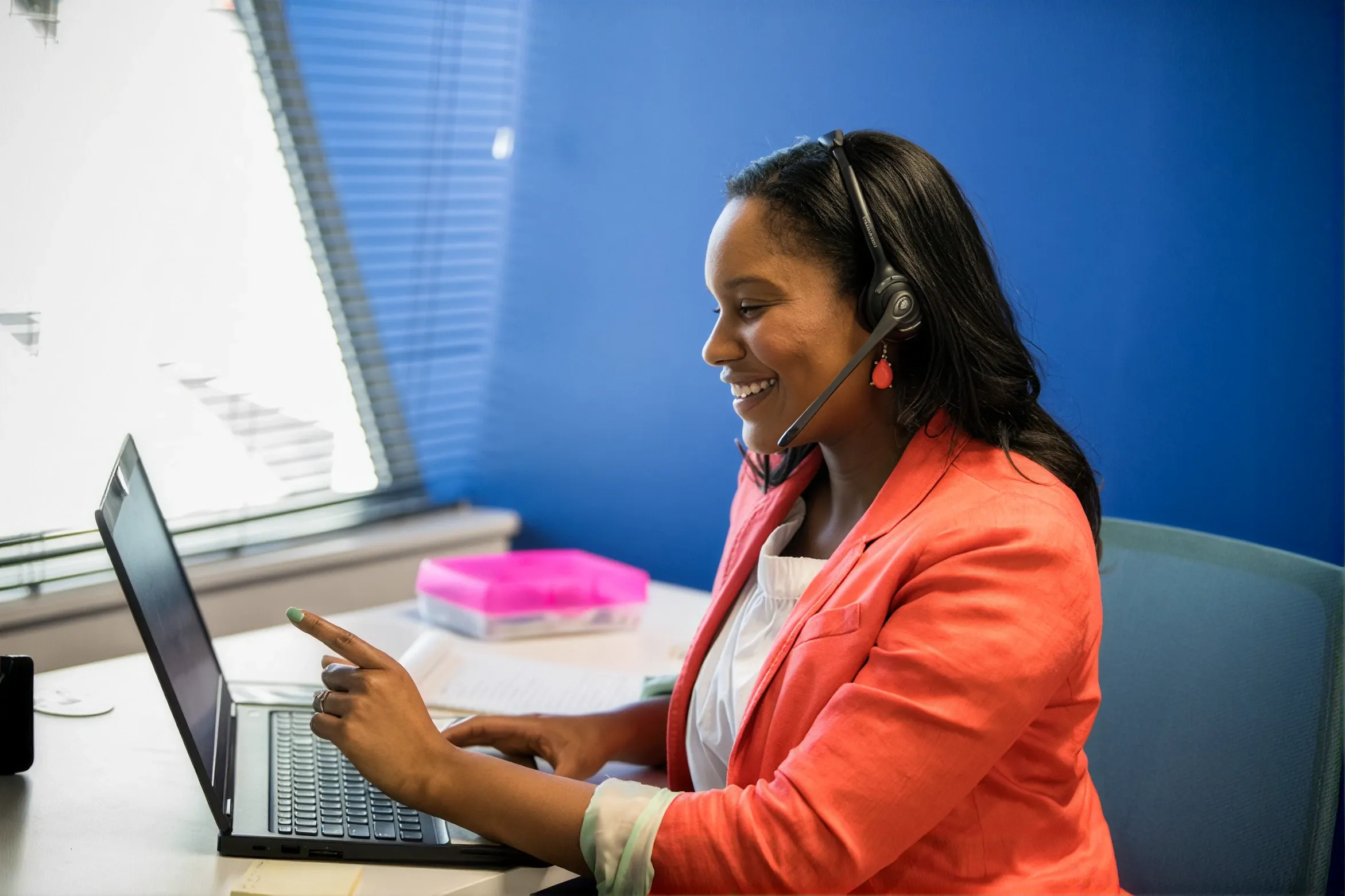 Woman In A Pink Blazer Wearing Headset